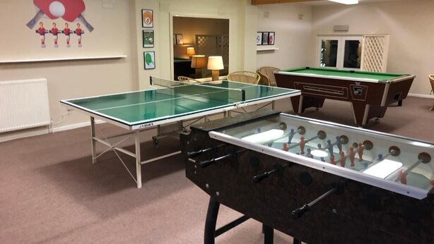 A room with a foosball table, a ping pong table, and a pool table. - Park Manor Hotel (Scarborough)