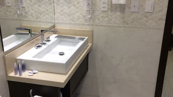 Un baño moderno con un espejo grande, un lavabo y un perchero para toallas.