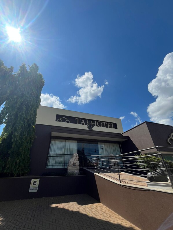 Un bâtiment moderne avec une enseigne indiquant « HÔTEL TAI ».