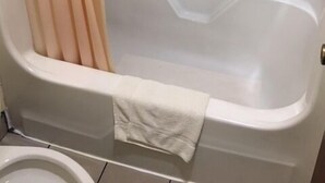 Une salle de bain avec une baignoire, des toilettes et un rideau de douche.