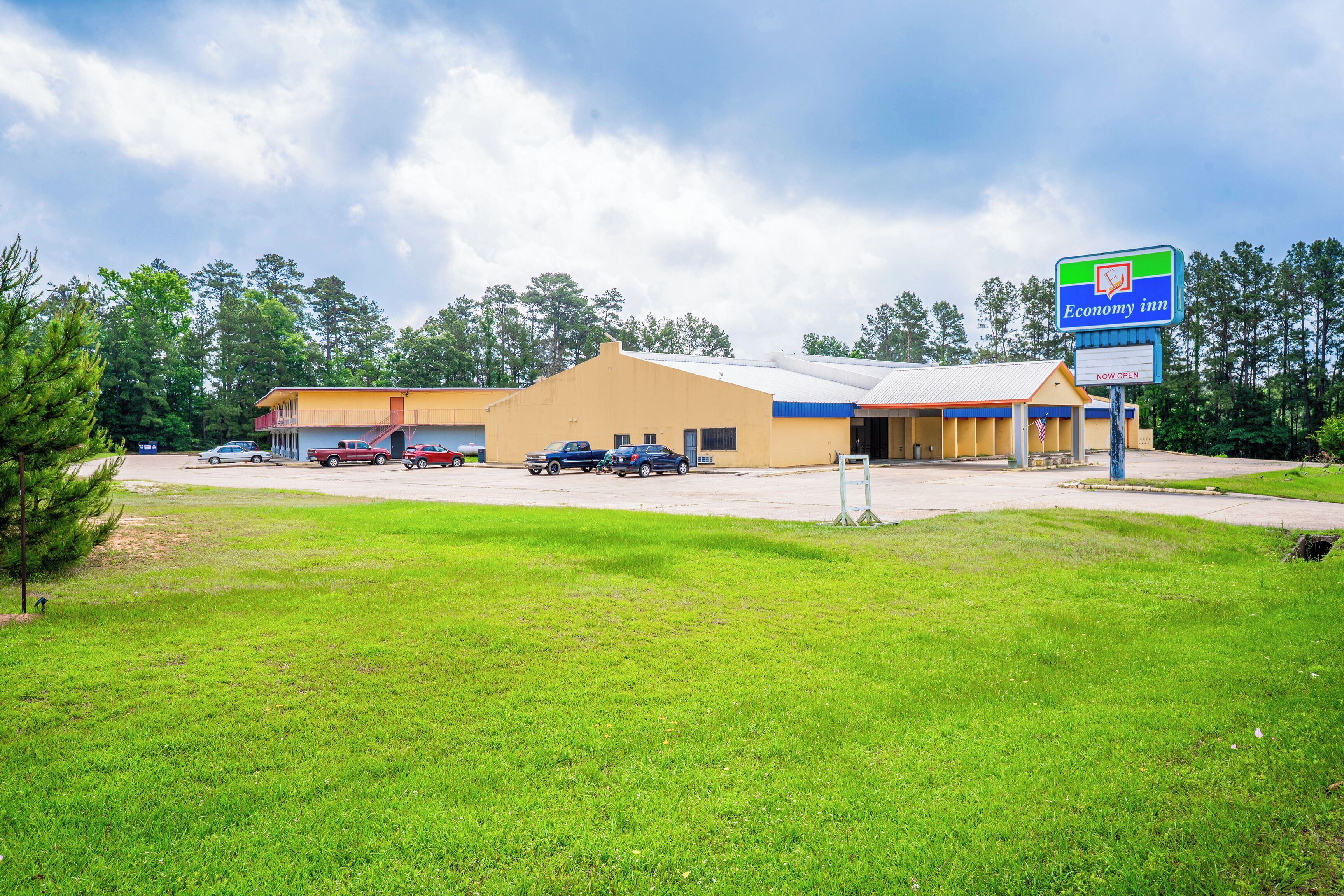 A two-story building with a sign for Economy Inn. There are several parked cars in front.