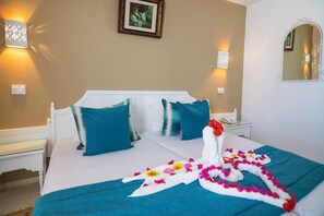 A hotel room with a bed, a nightstand, a wall-mounted mirror, and decorative wall sconces. - Hotel Tmk Marine Beach (Djerba Midun)
