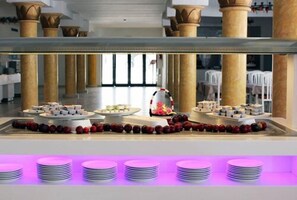A buffet setup with various food items and a decorative centerpiece. - Hotel Tmk Marine Beach (Djerba Midun)