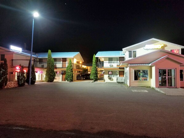 A hotel with a central courtyard, multiple buildings, and a well-lit street.