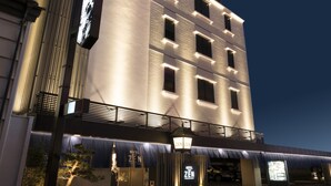 Un hotel moderno con un diseño vertical llamativo, amplias ventanas y una entrada bien iluminada.
