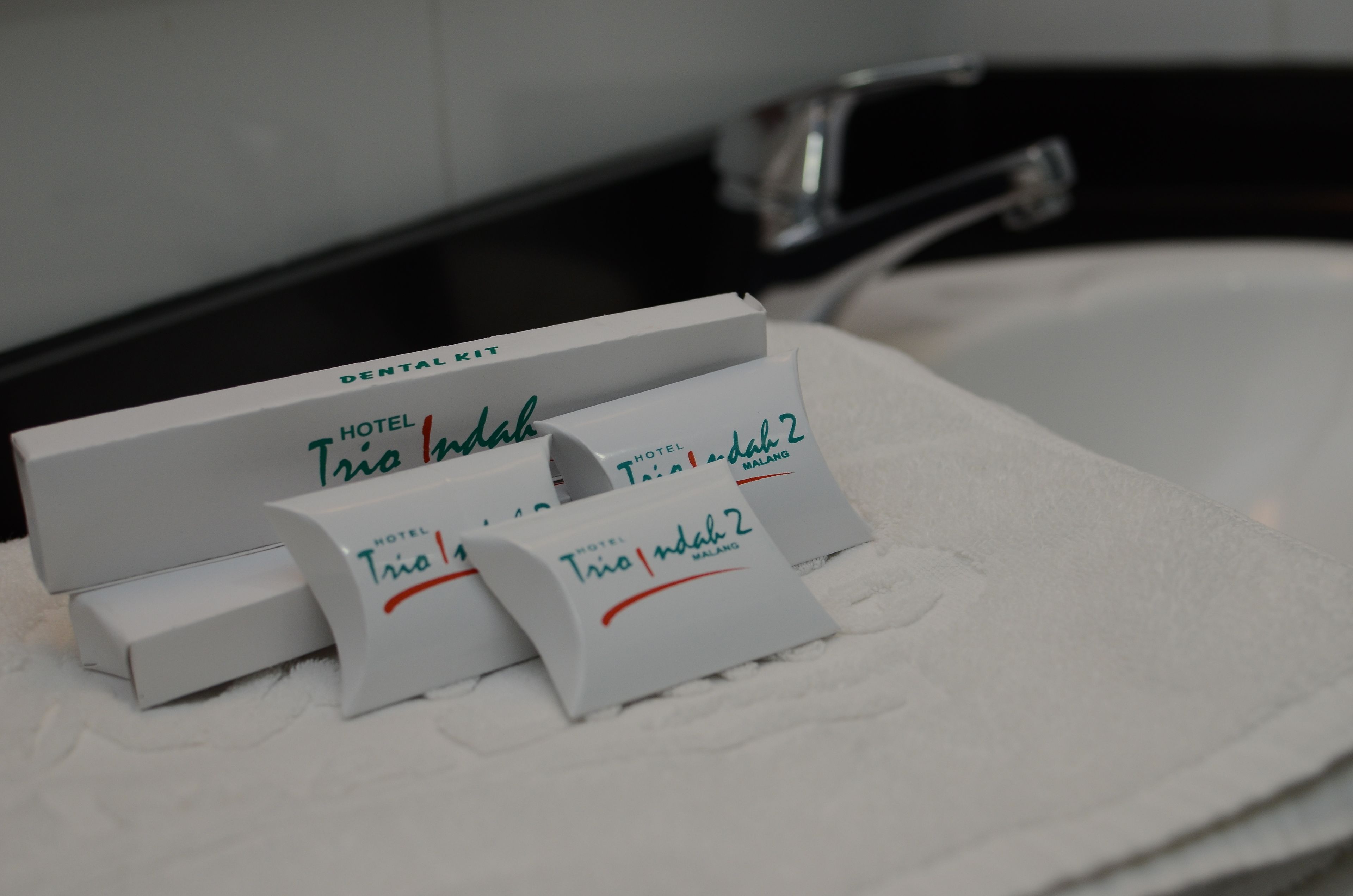 A hotel room with a white bathtub, a white towel, and a white tray with text indicating hotel amenities.