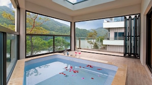 A modern indoor swimming pool with a view of a lake and mountains. - Ethren Resort (Gapyeong)