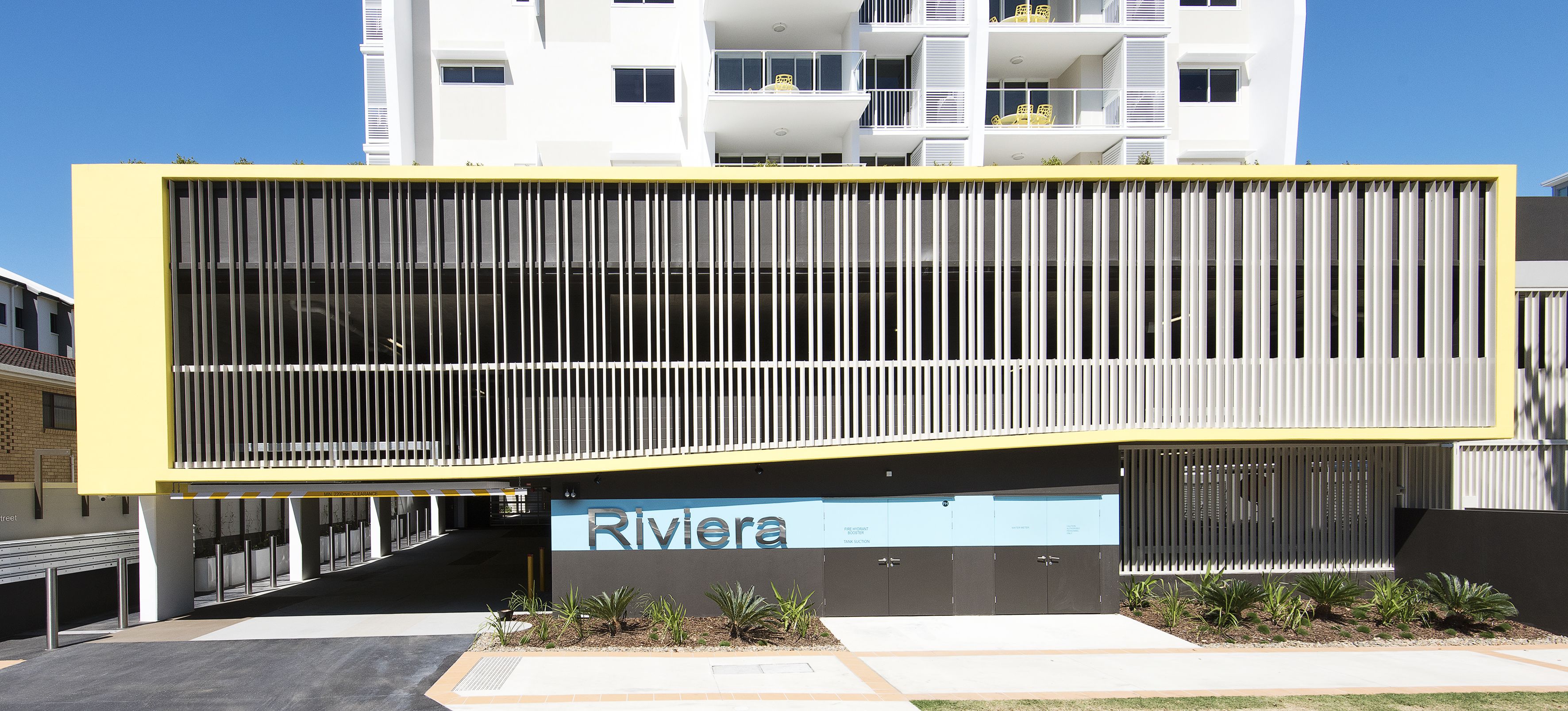 A modern building with a yellow facade and a sign reading "Riviera".