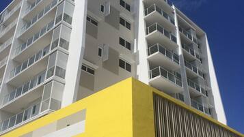 A high-rise building with multiple balconies and a yellow facade.