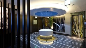 A modern lobby with a central circular light fixture, a reception desk, and a patterned floor. - Hotel Watergate Okayama - Adults Only (Okayama)