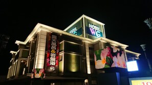 A hotel with a prominent sign reading "HOTEL WG" and a large digital display.