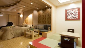 A modern, well-lit room with a sofa, a small table, and a chair. - Hotel Watergate Okayama - Adults Only (Okayama)