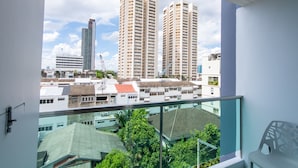 Um edifício alto com vários andares, janelas amplas e uma varanda.