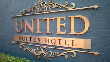 A sign for the United Suites Hotel with decorative elements.