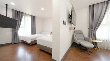 Une chambre d’hôtel moderne équipée d’un lit, d’un bureau, d’une chaise, d’une télévision et d’une fenêtre avec des rideaux.
