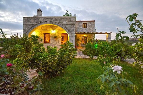 A stone house with an arched entrance and a small attached structure.