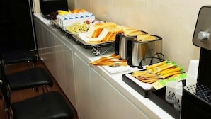 A buffet setup with various food items and a coffee machine. - Havana Hotel (Gwangju)
