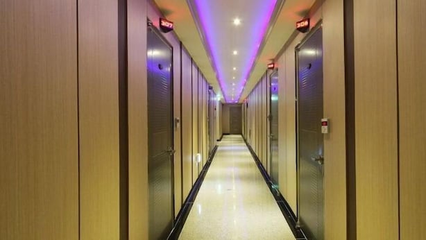 A hotel corridor with a long, narrow layout, featuring a series of doors on either side. - Havana Hotel (Gwangju)