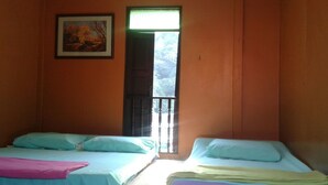 Una habitación con dos camas, un ventanal con vistas y un cuadro en la pared.