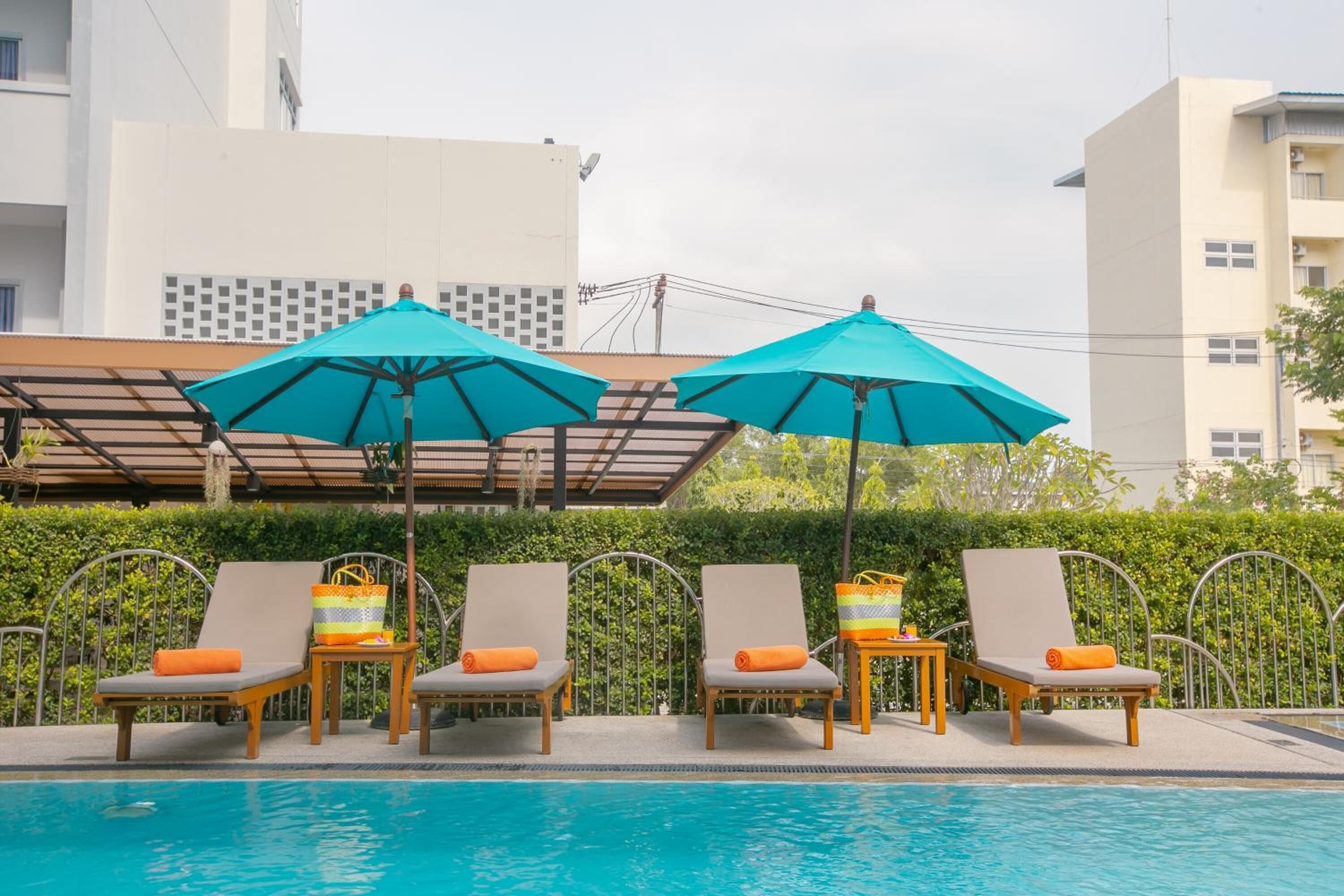 A poolside area with lounge chairs and umbrellas.