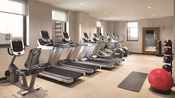 A gym with treadmills, exercise balls, and weights.