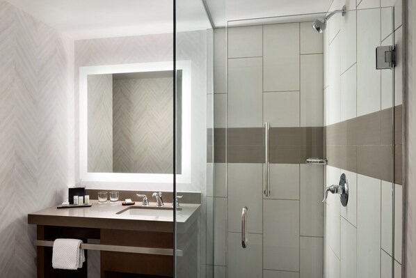 A modern bathroom with a glass shower enclosure, a large mirror, and a vanity with a towel rack. - Embassy Suites By Hilton Pittsburgh Downtown (Pittsburgh)