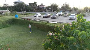 Un estacionamiento con varios coches y un aro de baloncesto al frente.