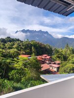 Un paisaje montañoso con una casa de varios niveles y tejado rojo.