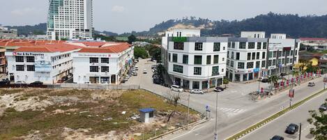 A multi-story building with a flat roof and a sign that reads "KAMDAR".