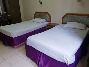 Two twin beds with purple bed skirts and white linens in a hotel room. - Champcity Hotel (Kuantan)