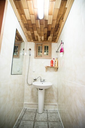 A bathroom with a wooden ceiling, a white sink, and a shower. - Ilrakdang (Jeonju)