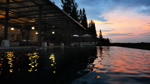 A modern outdoor pool area with a covered seating area and lounge chairs. - The Farmhouse at Polo Escape (Sattahip)