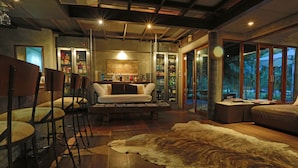 A modern interior with a bar area, seating, and a large fur rug. - The Farmhouse at Polo Escape (Sattahip)
