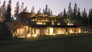A modern two-story house with a covered patio and multiple illuminated windows. - The Farmhouse at Polo Escape (Sattahip)