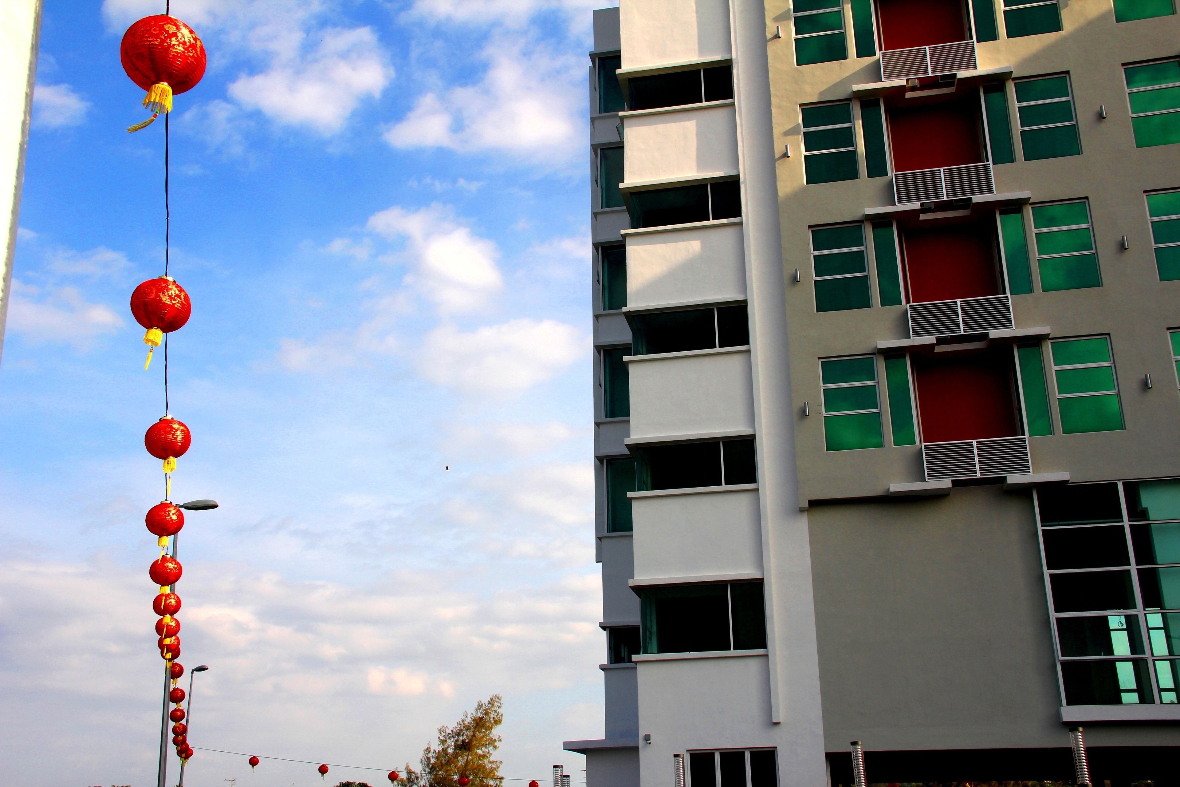 A building with multiple floors, balconies, and a clear sky.