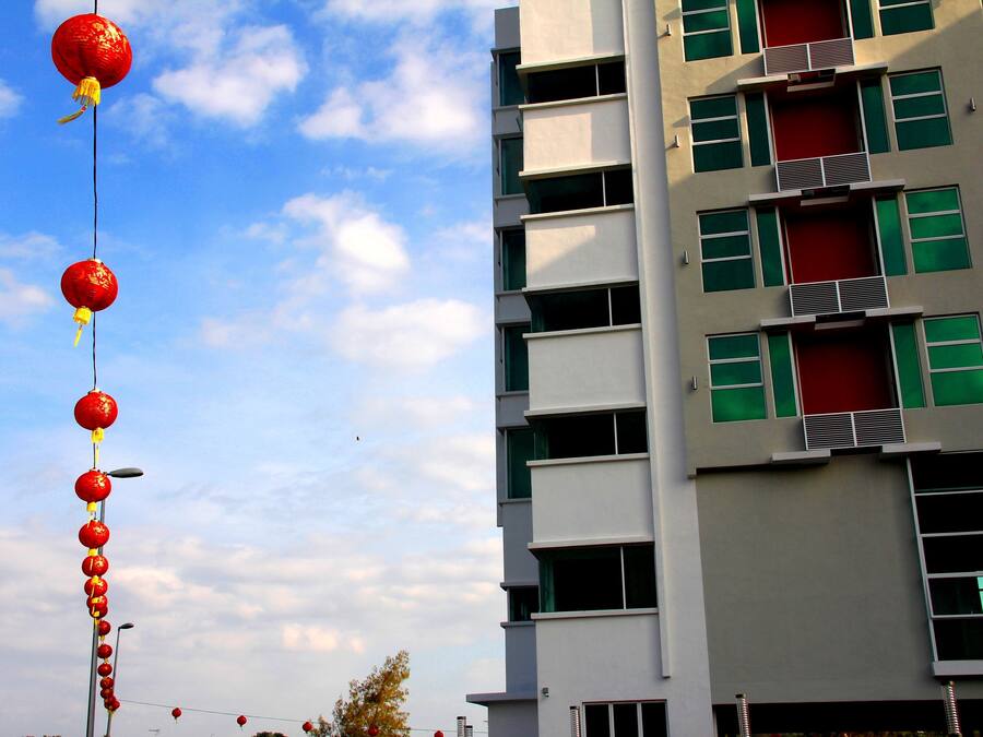 A building with multiple floors, balconies, and a clear sky.