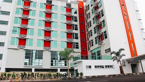 Un immeuble à plusieurs étages doté d’une architecture moderne, avec des balcons et de grandes fenêtres.