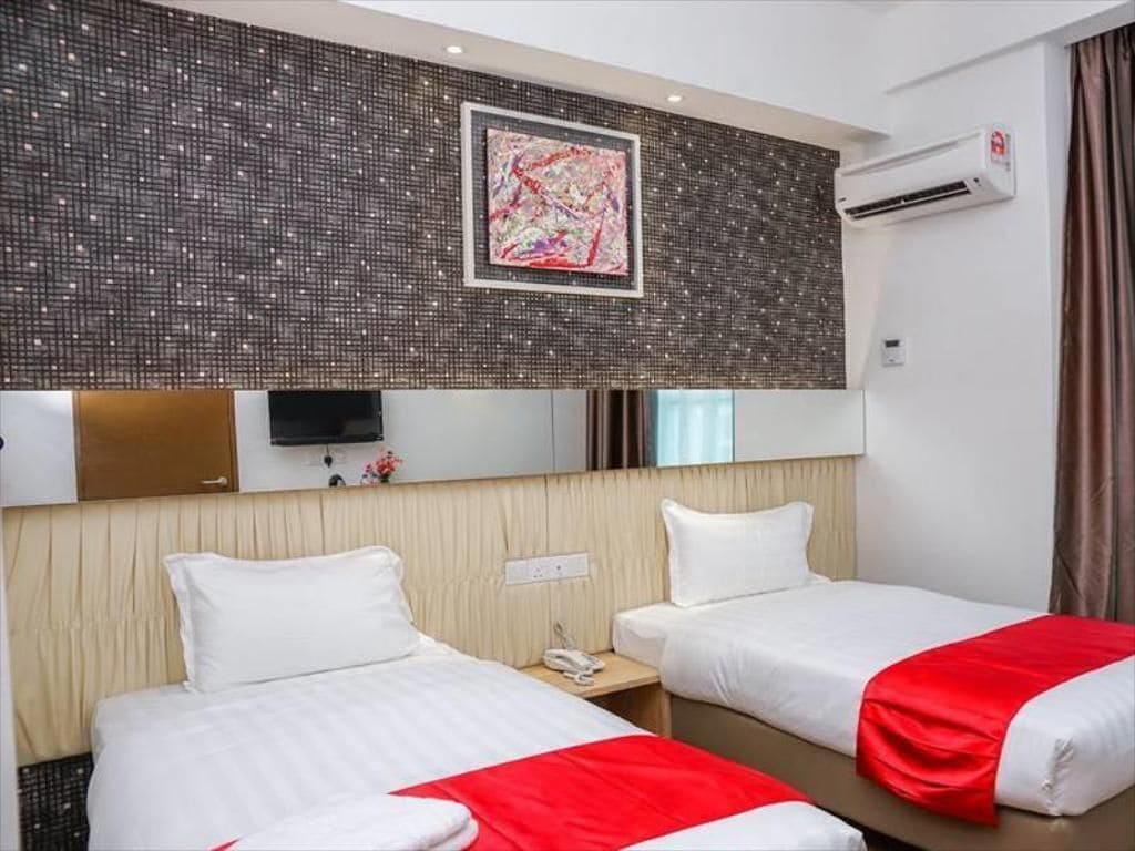 A hotel room with two beds, a large mirror, a flat-screen TV, and an air conditioning unit.