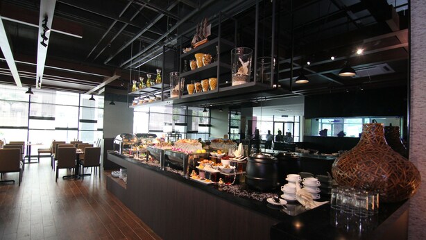 Uma área de buffet com diversos alimentos e um vaso decorativo.