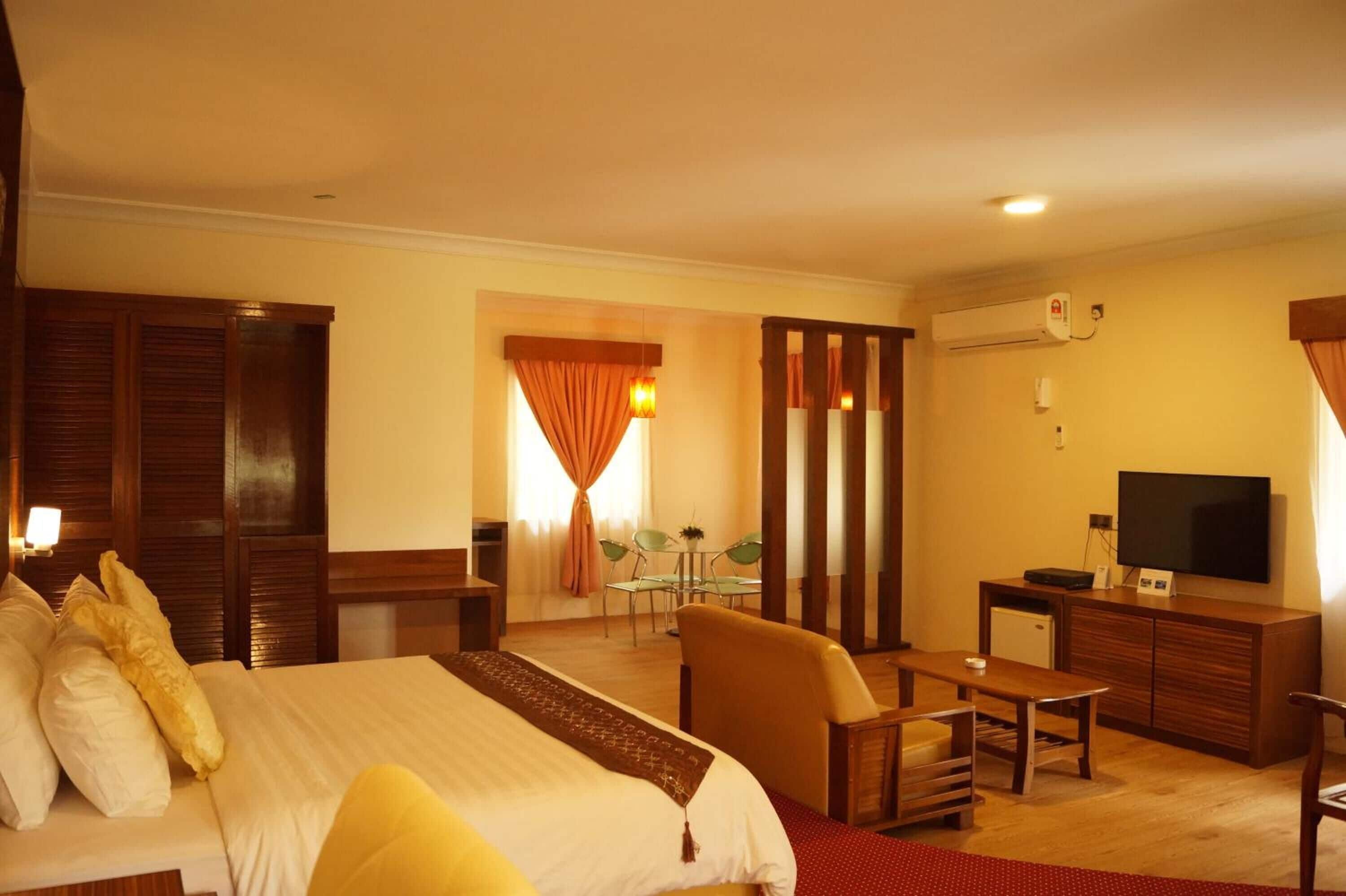 A hotel room with a bed, a desk, a television, and a small table.