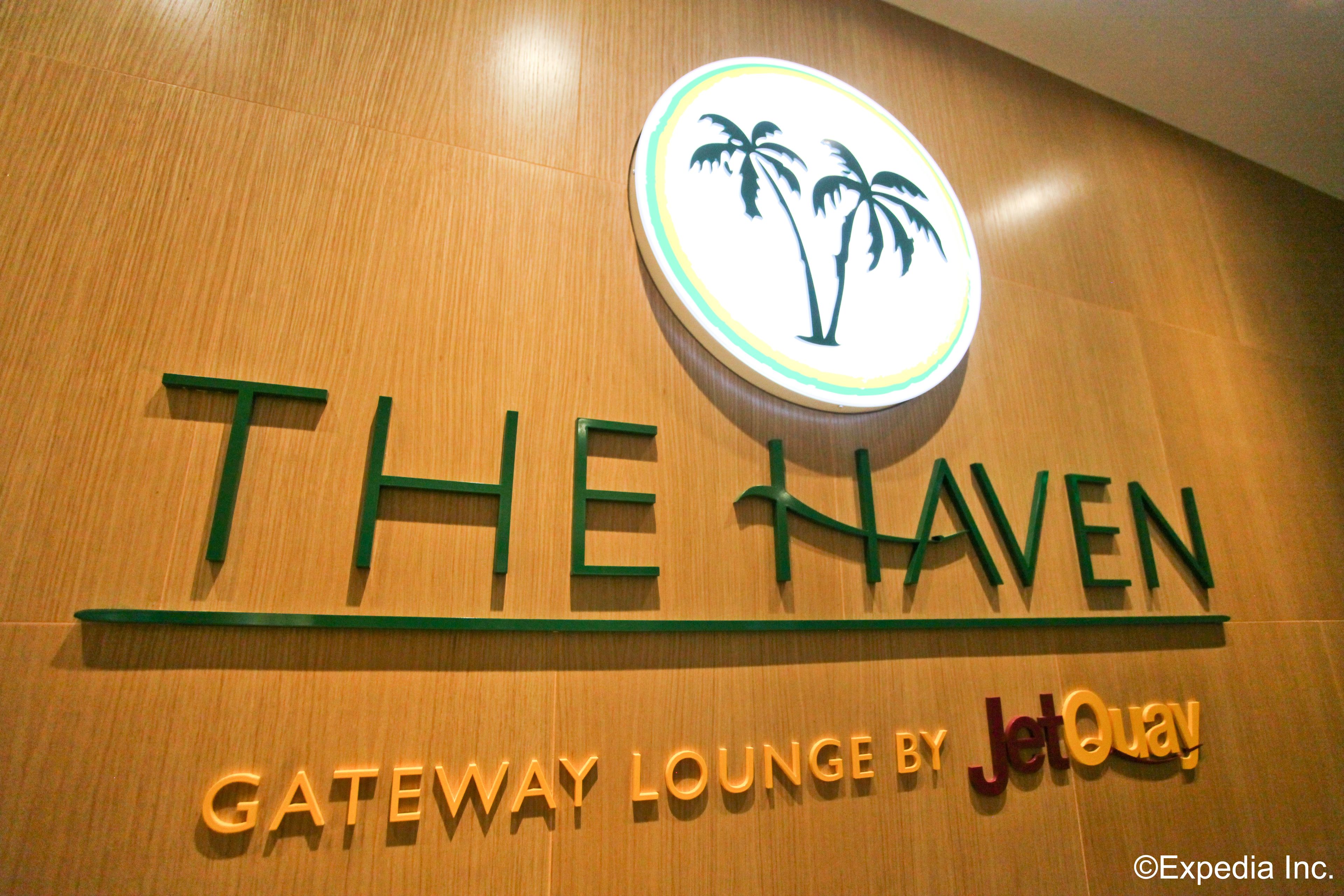 A sign for "The Haven" with palm tree graphics and "Gateway Lounge by JetQuay" text.