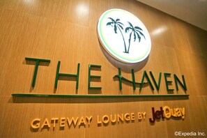 A sign for "The Haven" with palm tree graphics and "Gateway Lounge by JetQuay" text. - The Haven by JetQuay (Singapore)