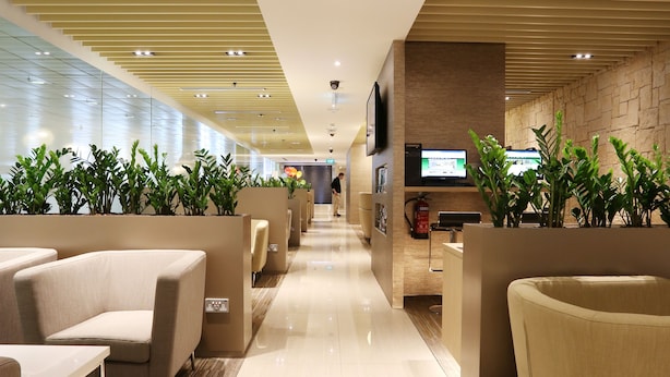 A modern hotel lobby with a long, polished floor, seating areas with sofas, and a reception desk. - The Haven by JetQuay (Singapore)