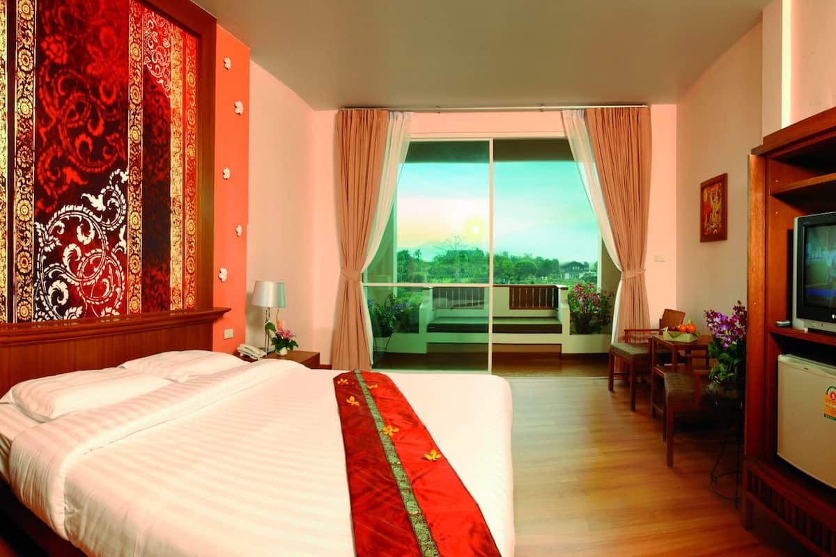 Habitación de hotel con una cama grande, televisión, balcón con vistas y una decoración de pared.