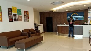 A hotel reception area with a modern design, featuring a reception desk, a waiting area with sofas, and motivational posters on the walls. - Tras Mutiara Hotel Bentong (Bentong)