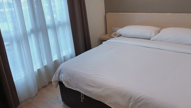 A hotel room with a large bed, a bedside telephone, and a window with curtains. - Tras Mutiara Hotel Bentong (Bentong)