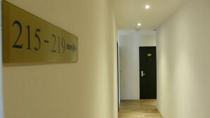 A hallway with a sign indicating room numbers 215-219. - Tras Mutiara Hotel Bentong (Bentong)
