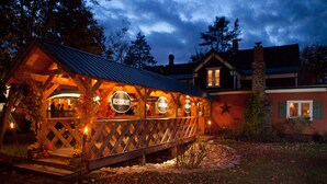 A wooden outdoor restaurant with multiple signs indicating different dining areas.