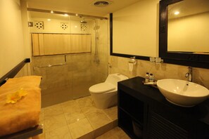 A bathroom with a shower, toilet, sink, and towel rack. - Kubu Soca Villa (Ubud)