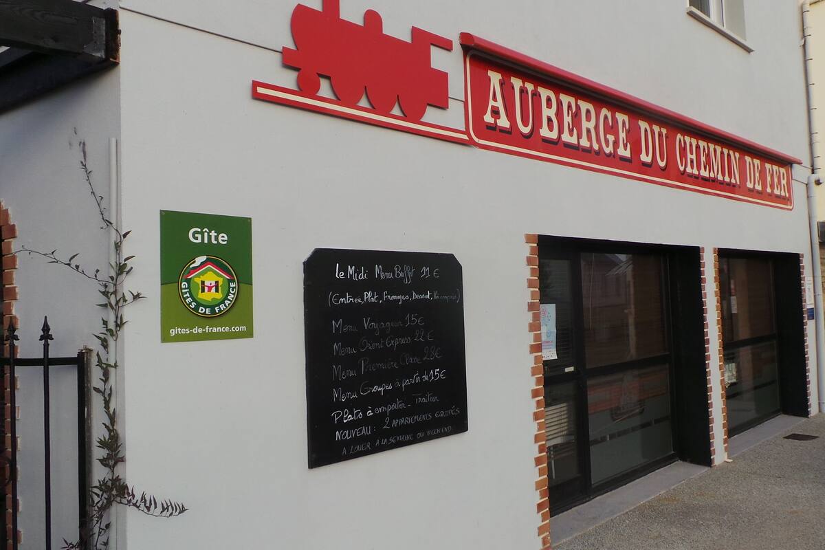 A restaurant named "Auberge du Chemin de Fer" with a signboard listing prices for different meal options.